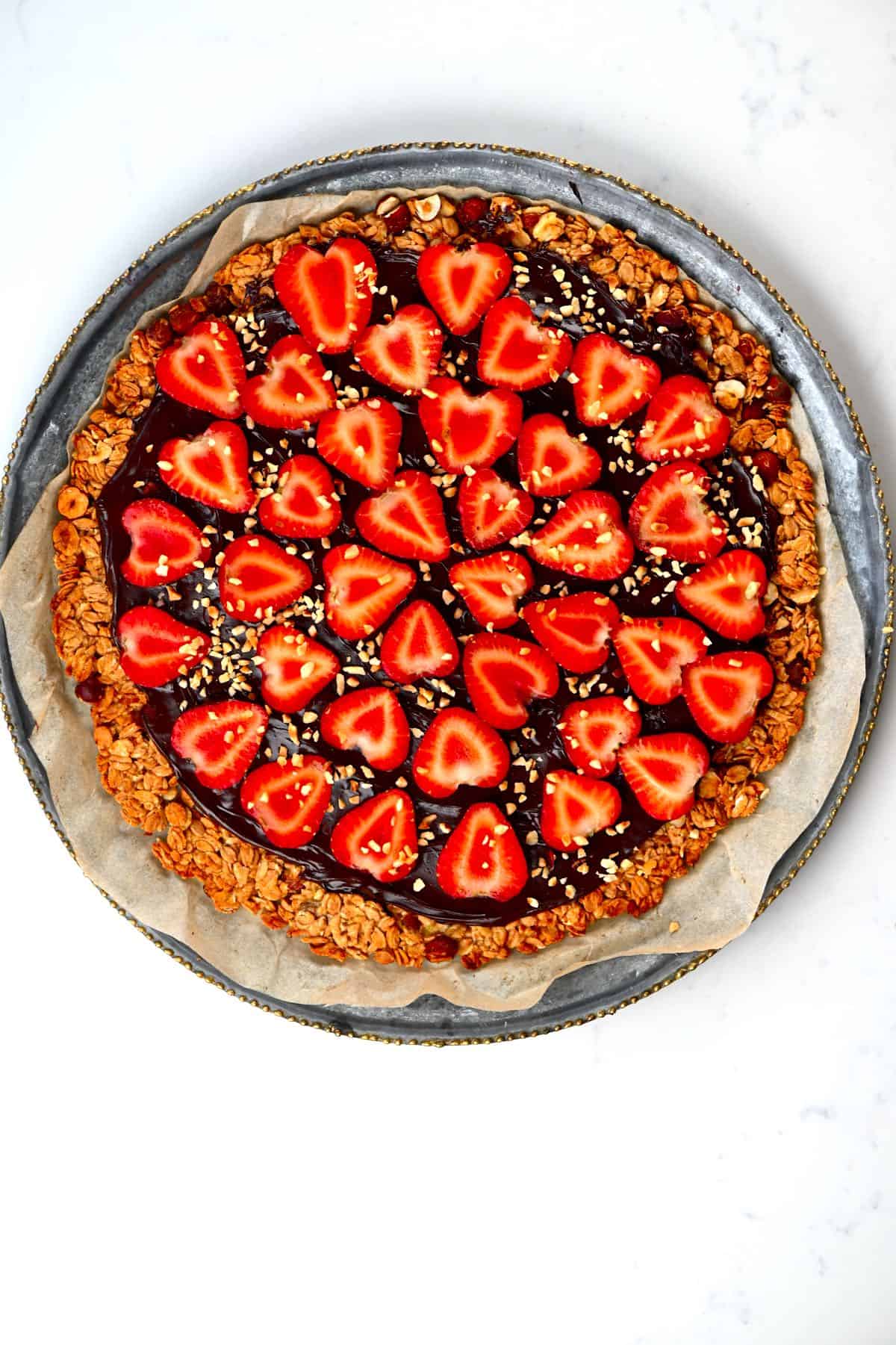 Strawberry Nutella Pizza on a baking sheet placed on a round tray
