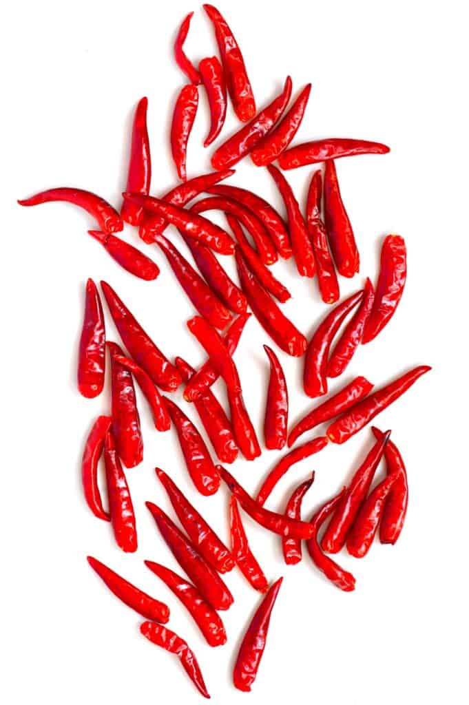 Red chili peppers spread on a white surface