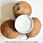 Homemade Extra Virgin Coconut Oil in a small bowl placed over three coconuts