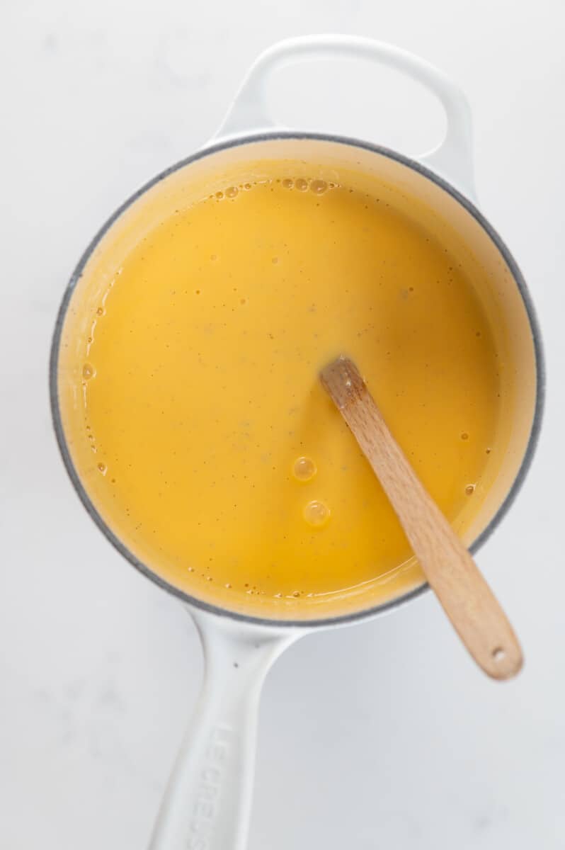 Vanilla custard in a pot with a wooden spoon
