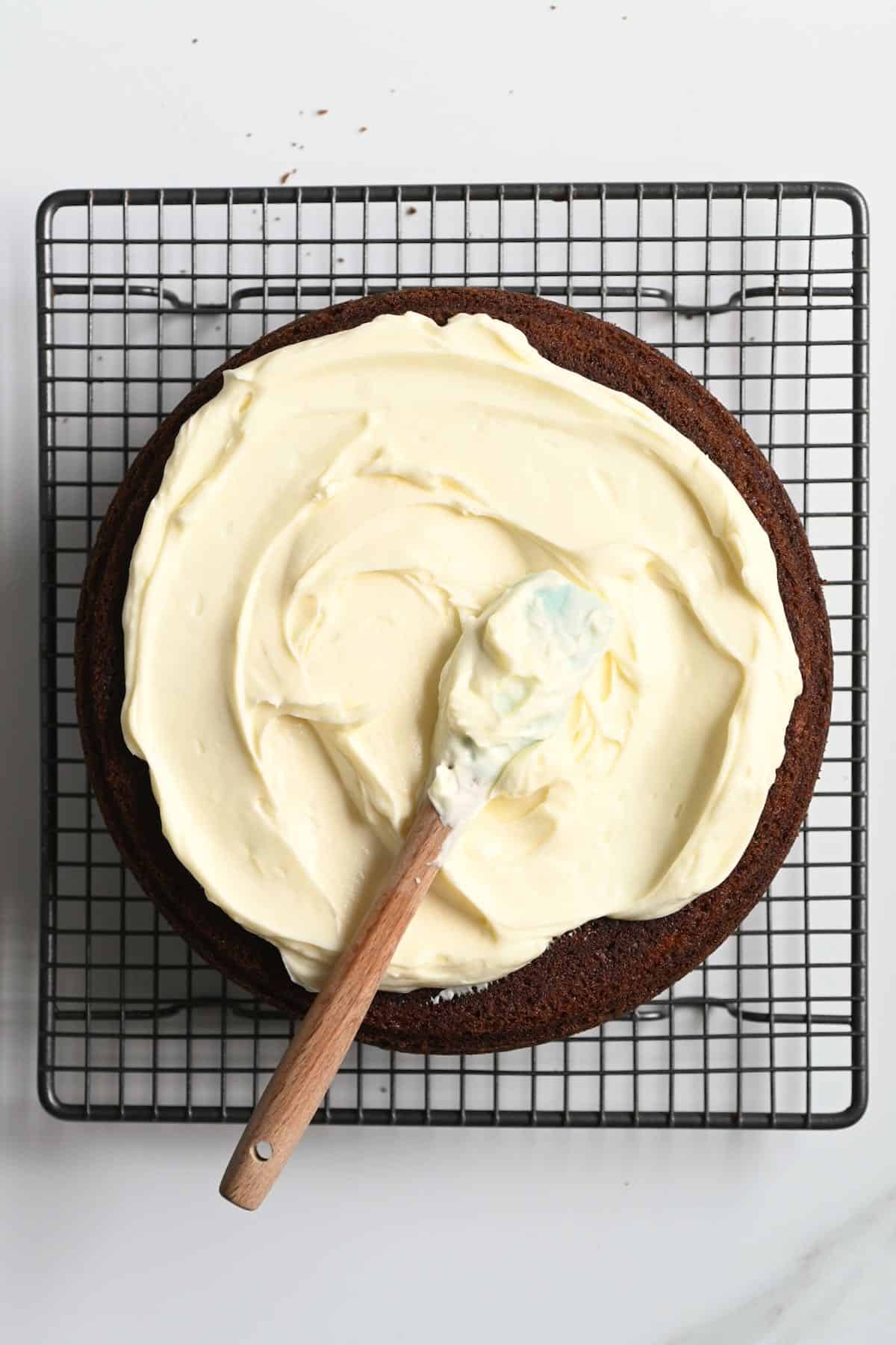 Frosted carrot cake and a spoon with frosting on top of it