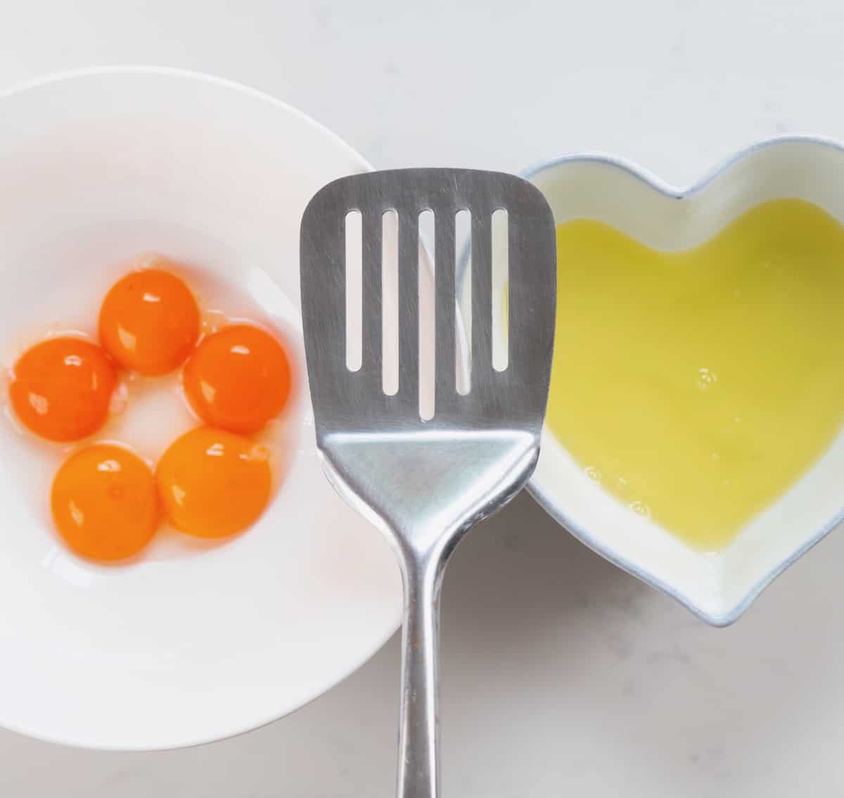 Separated egg yolks and egg whites in different bowls