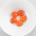 five egg yolks in a bowl