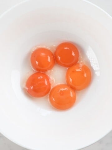 five egg yolks in a bowl