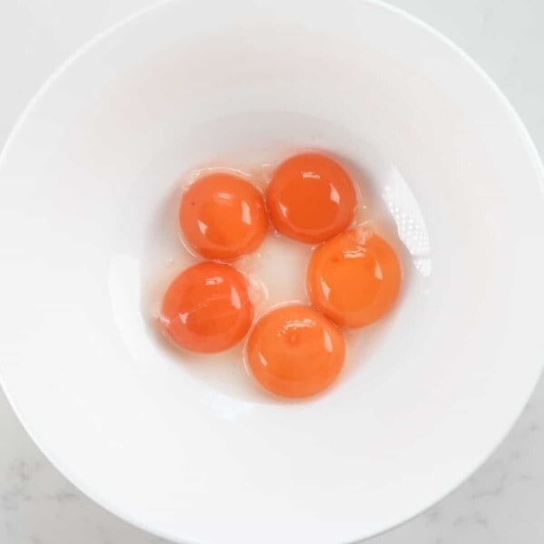 five egg yolks in a bowl