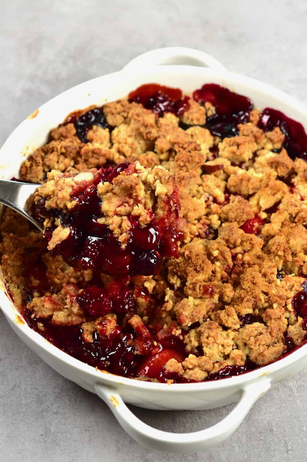 Berry crumble in a dish with a spoon