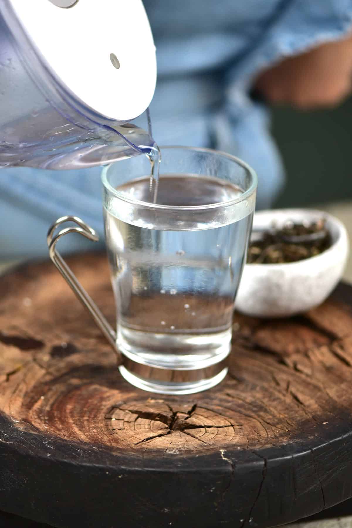 Adding cold water to a glass with hot water