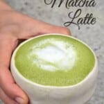 Hand holding a small bowl with matcha latte