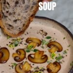A bowl of mushroom soup and a piece of bread being dipped into it