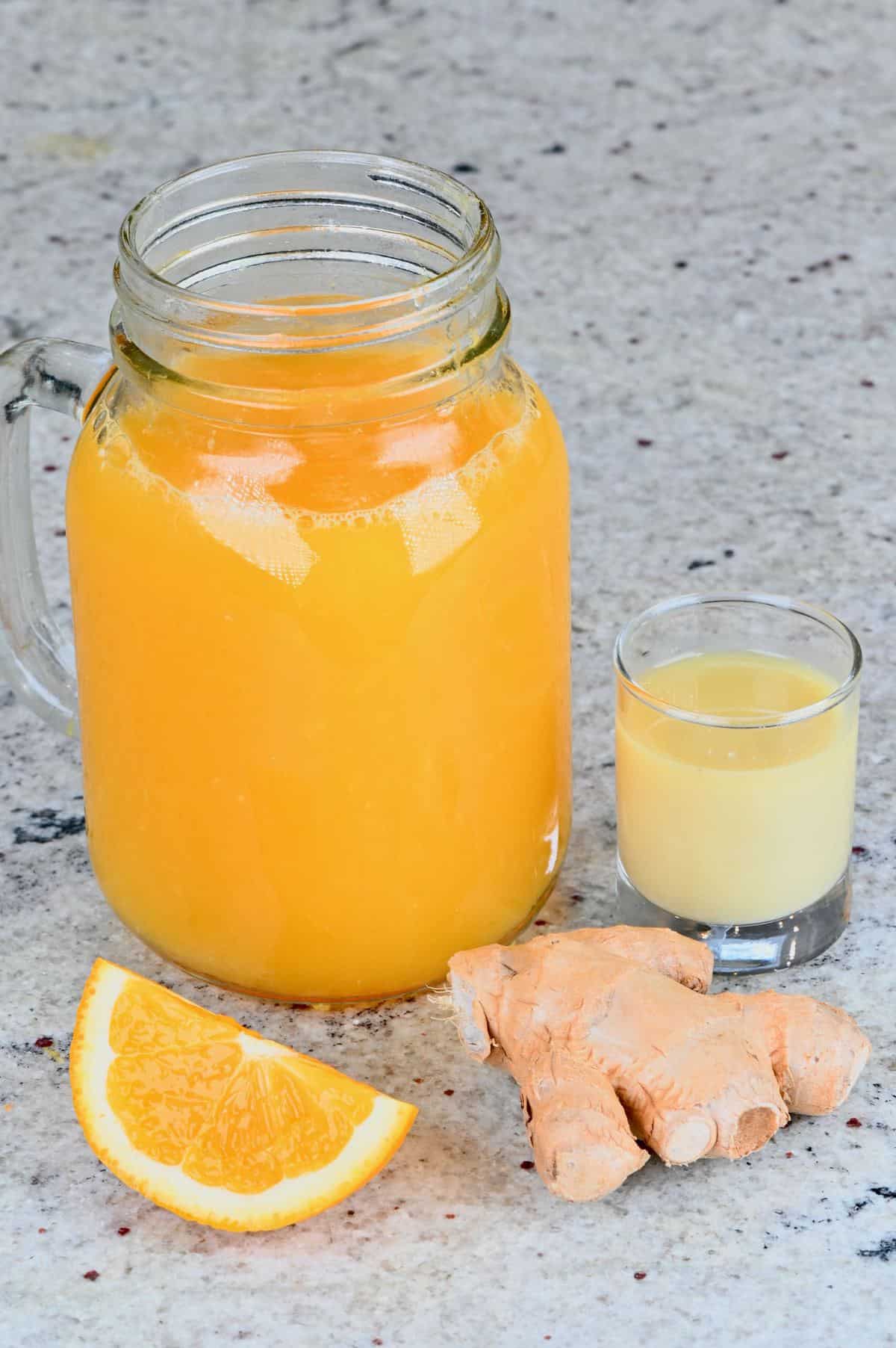 Orange juice in a mason jar and a small glass with ginger juice