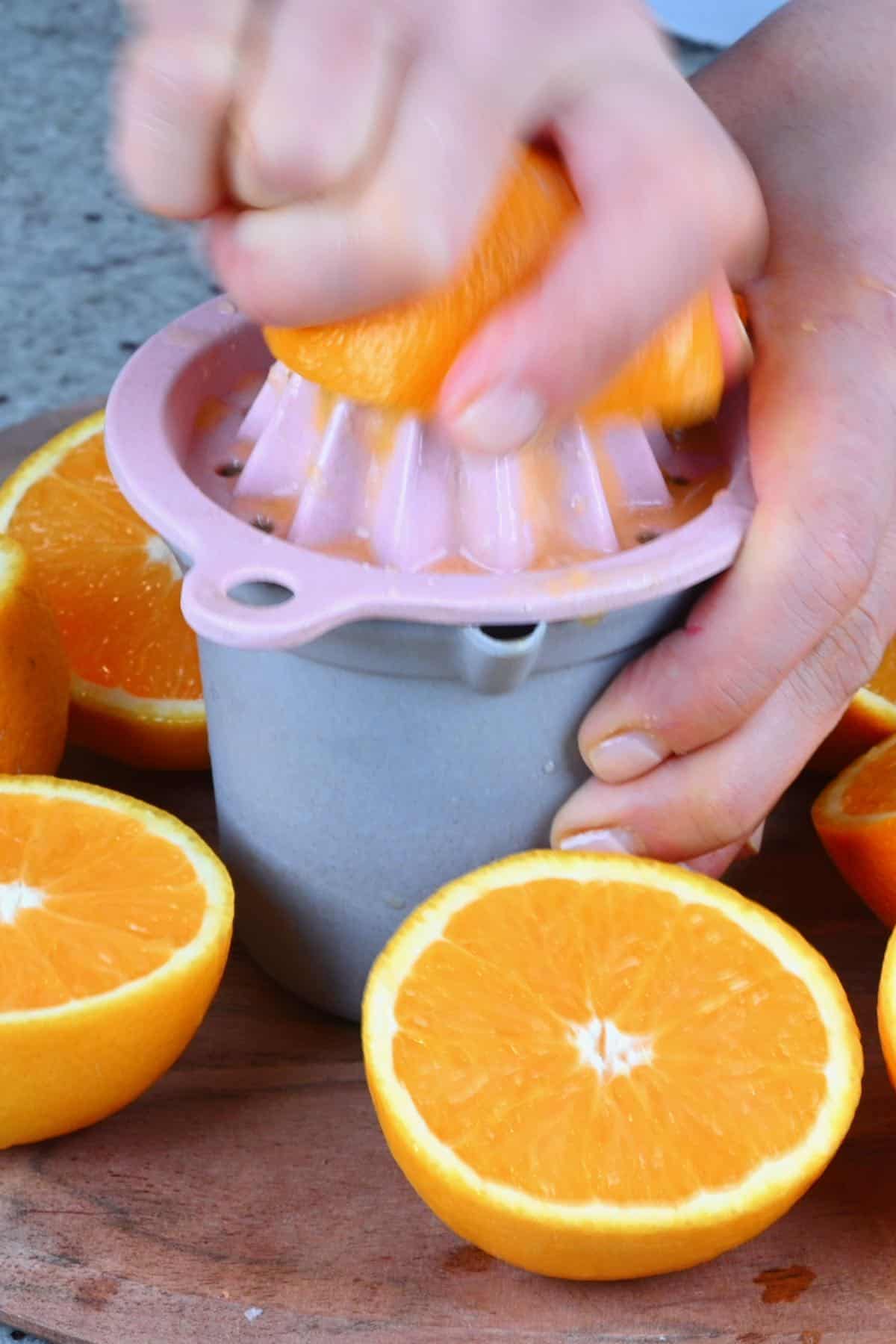 Juicing an orange on a citrus juicer