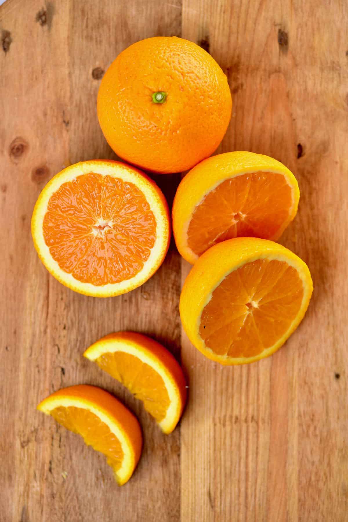 A whole orange and an orange cut into several pieces