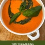 A bowl of tomato soup topped with basil leaves