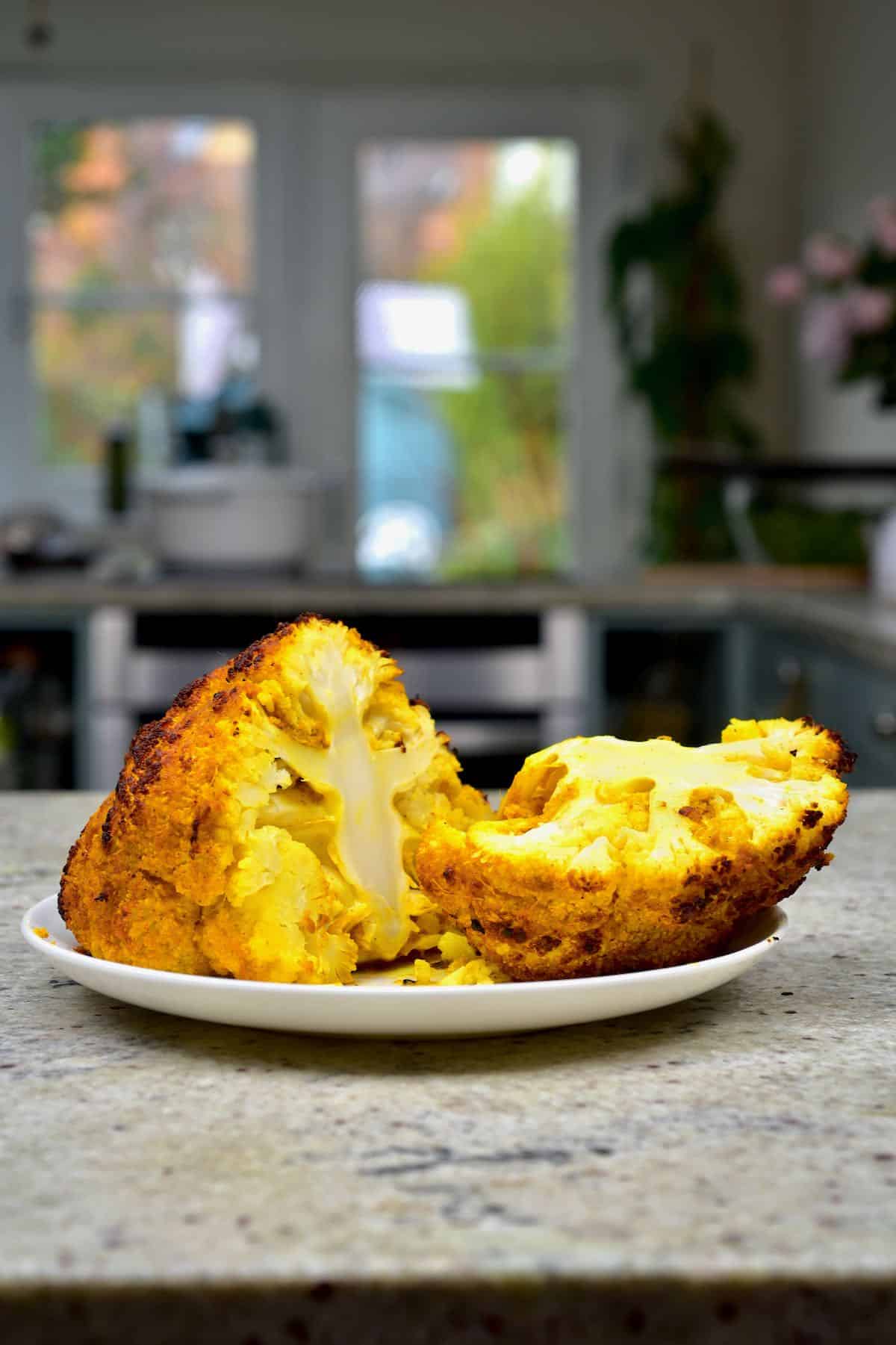 A baked turmeric covered cauliflower head cut in two