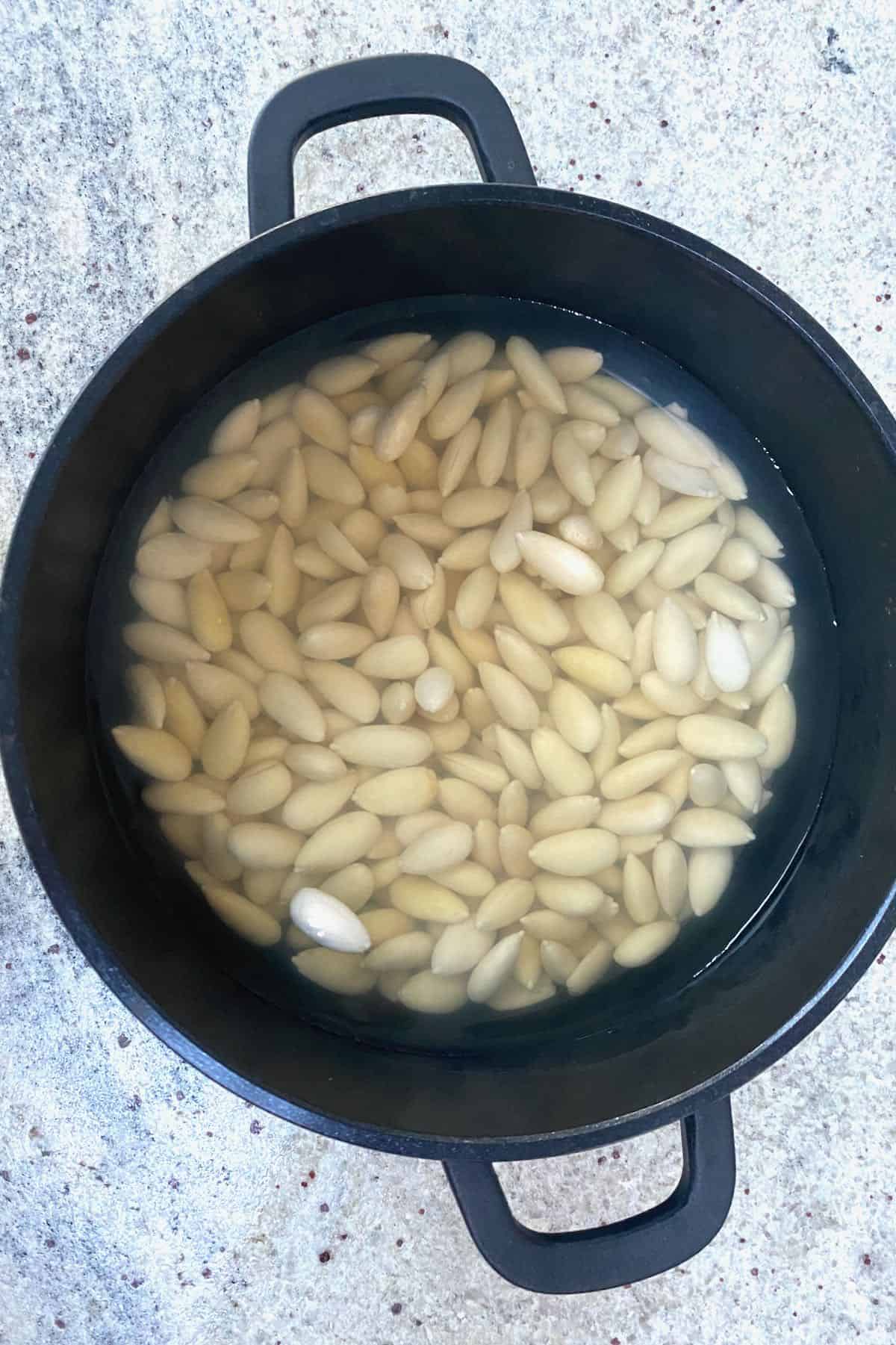 Soaking blanched almonds in a pot with water