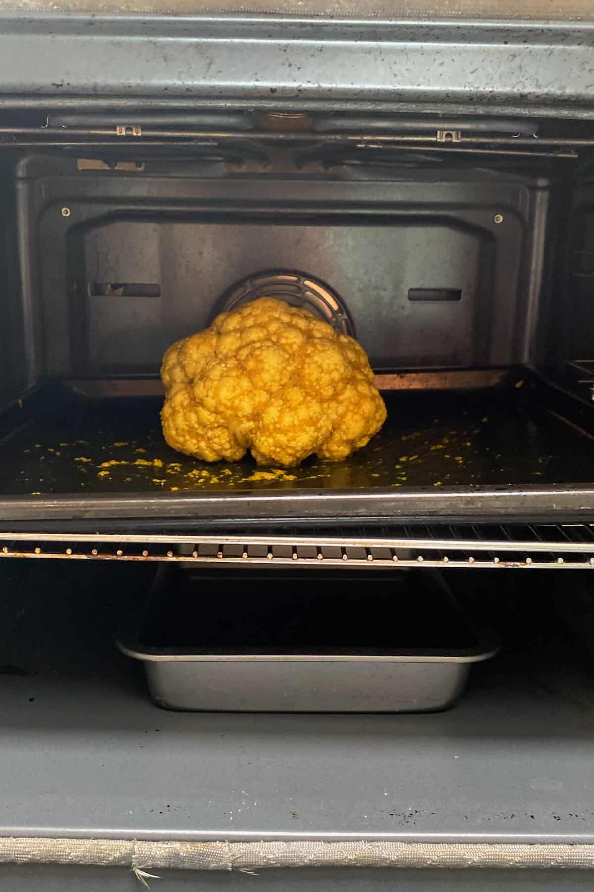 Cauliflower in the oven with a small tray under it