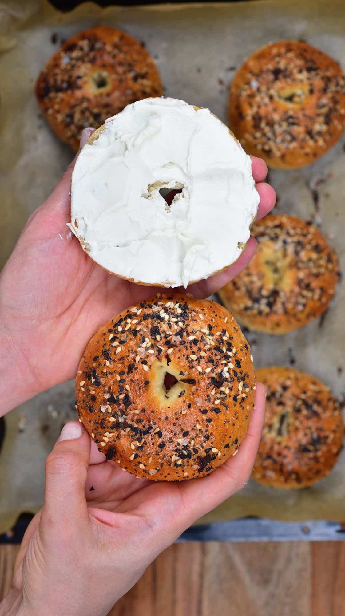 A bagel cut in two with cream cheese spread on one half
