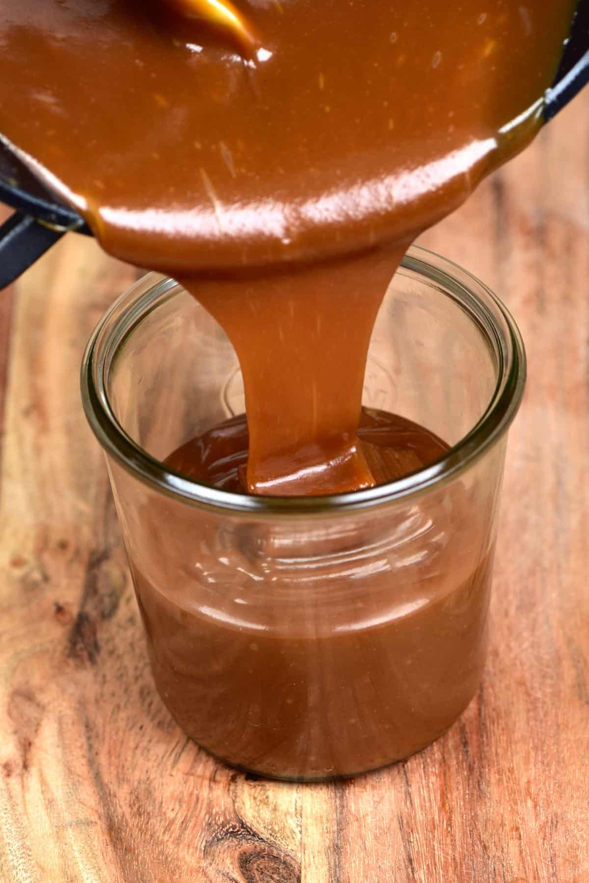Pouring homemade caramel into a jar