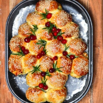 Christmas tree shaped cheese buns topped with rosemary and cranberries