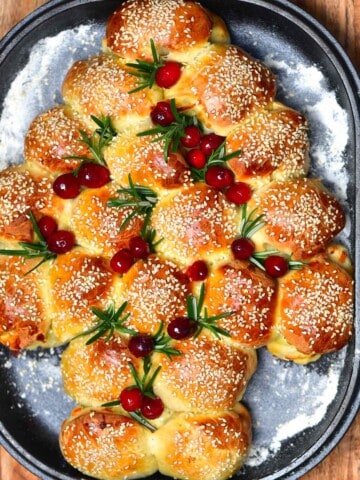 Christmas tree shaped cheese buns topped with rosemary and cranberries