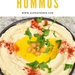 Hummus in a bowl topped with chickpeas and paprika