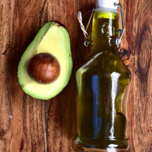 Half an avocado and a small bottle with homemade avocado oil