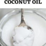 Close up of a spoonful of coconut oil over a jar