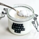 A spoon with Extra virgin coconut oil resting on a jar