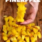The core of a pineapple and pieces of it laying around on a board