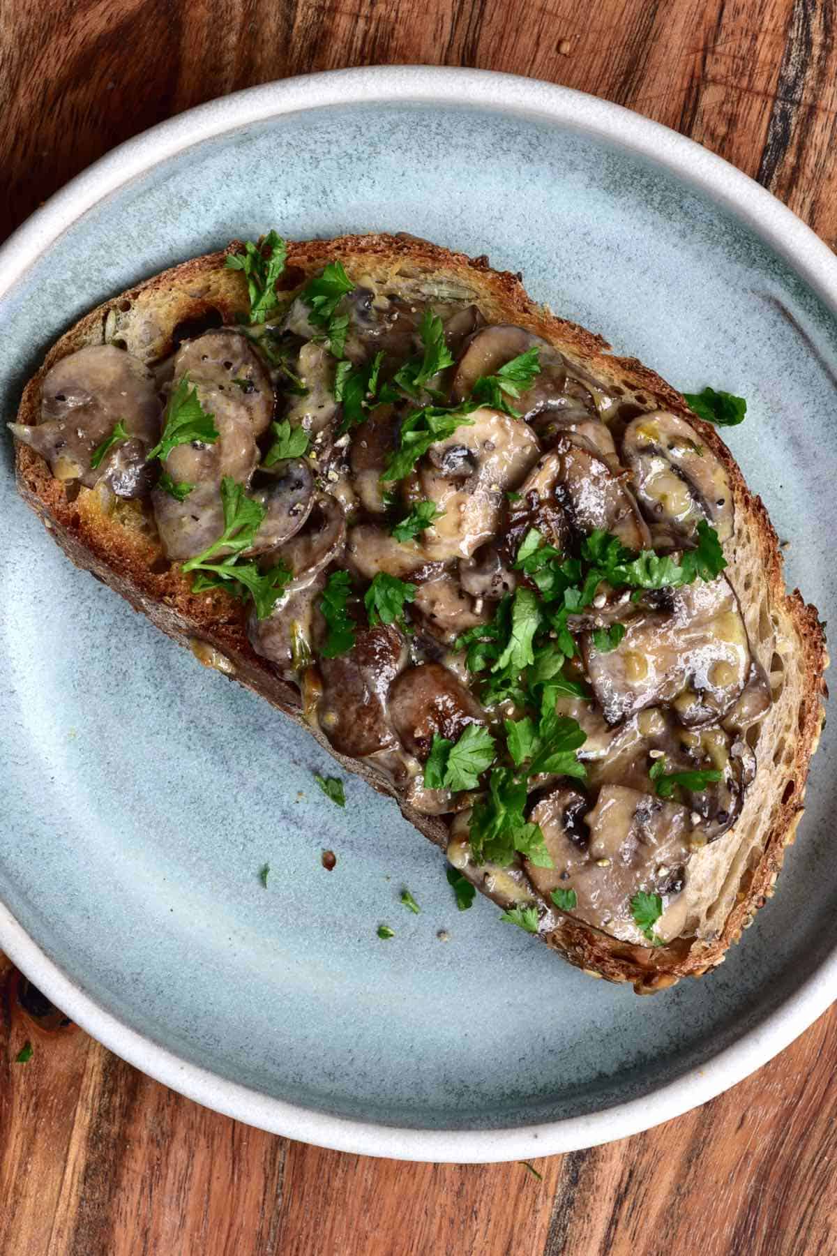 Toasted bread topped with mushrooms in a round plate