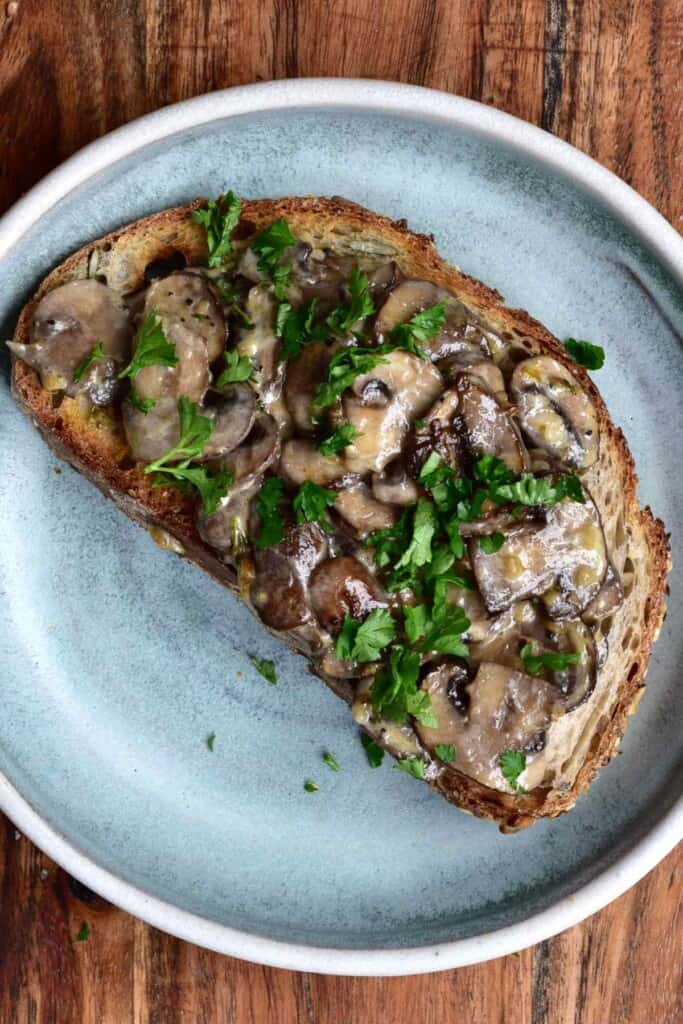 Toasted bread topped with mushrooms in a round plate
