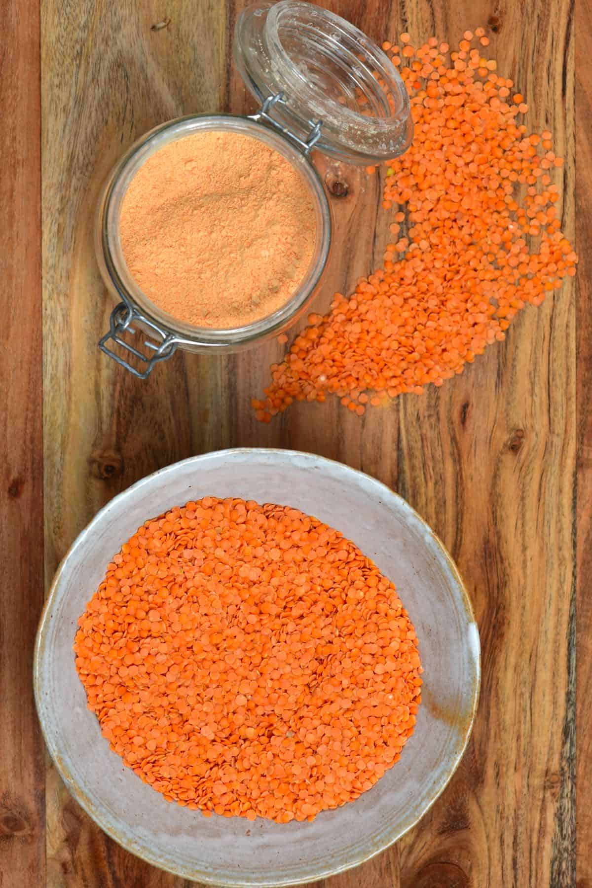 A jar with red lentil flour and red lentils in a bowl