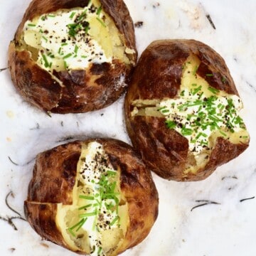 Three salt baked potatoes topped with cream and herbs