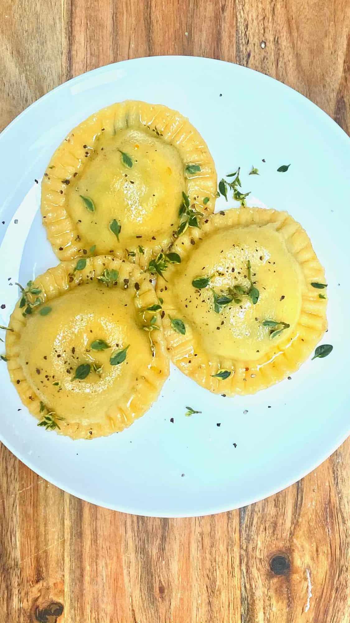 Three homemade ravioli with spinach filling in a plate