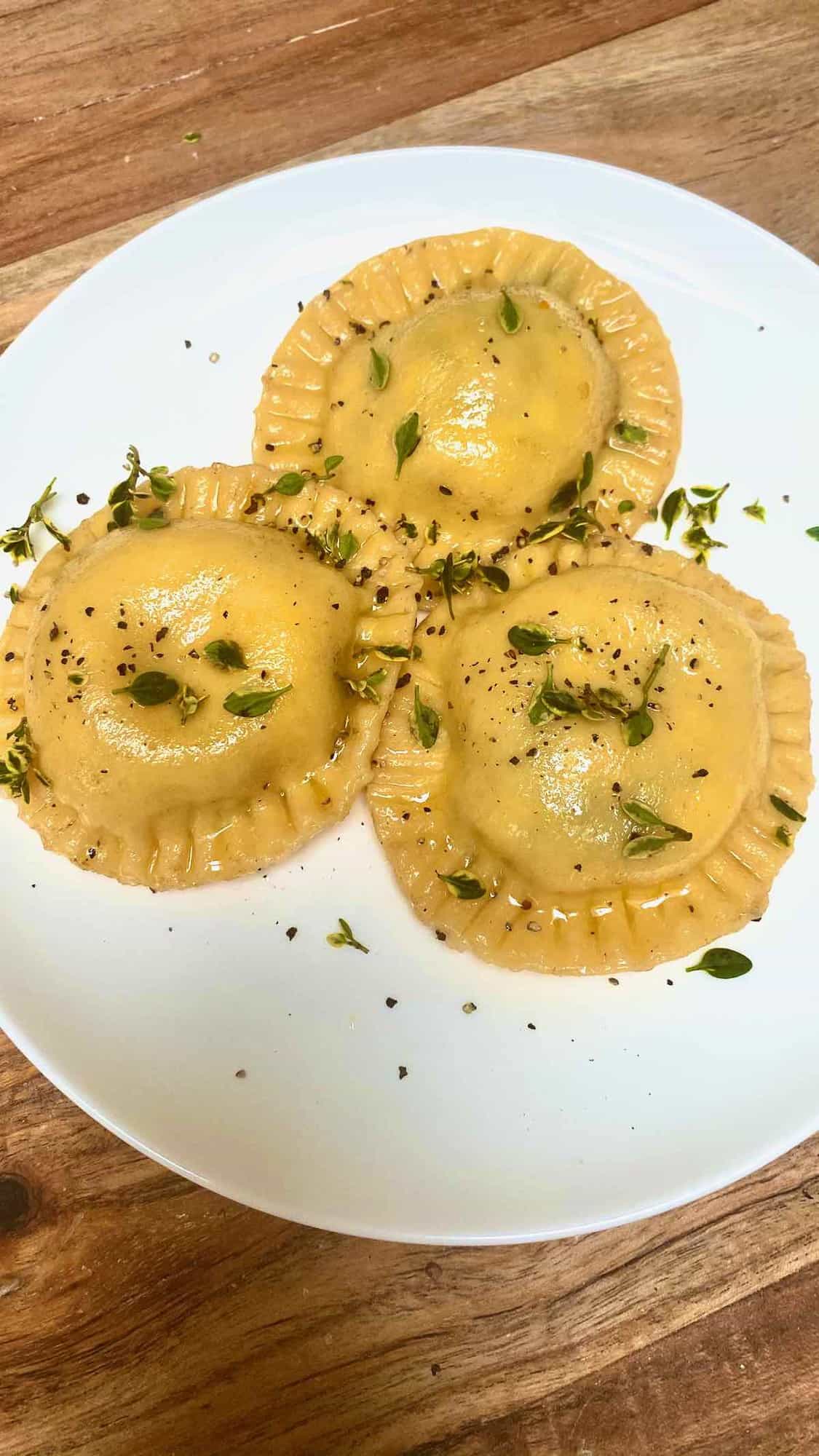 Three homemade ravioli with spinach filling in a plate