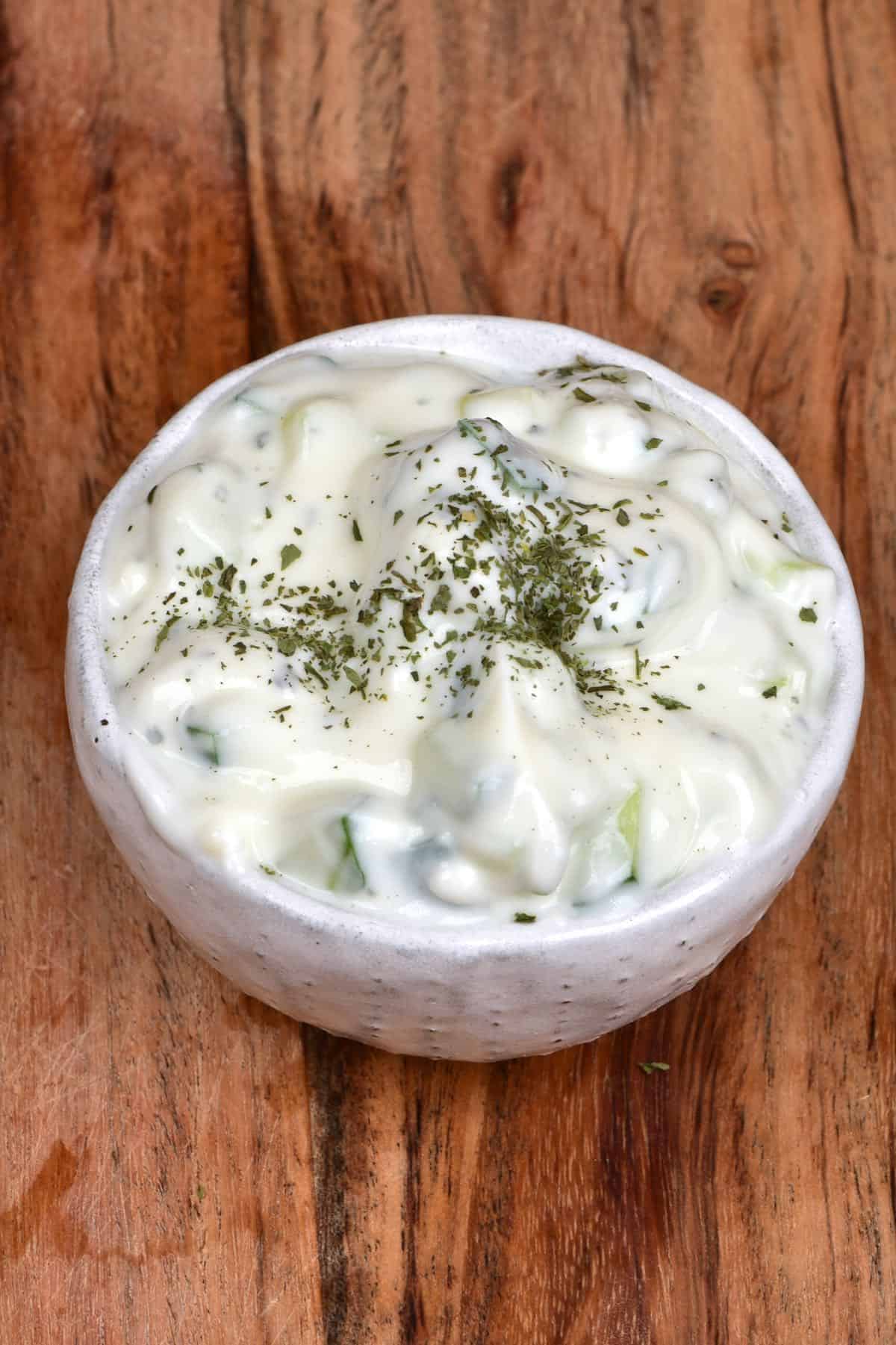 Yogurt Cucumber Salad served in a small bowl topped with dried mint