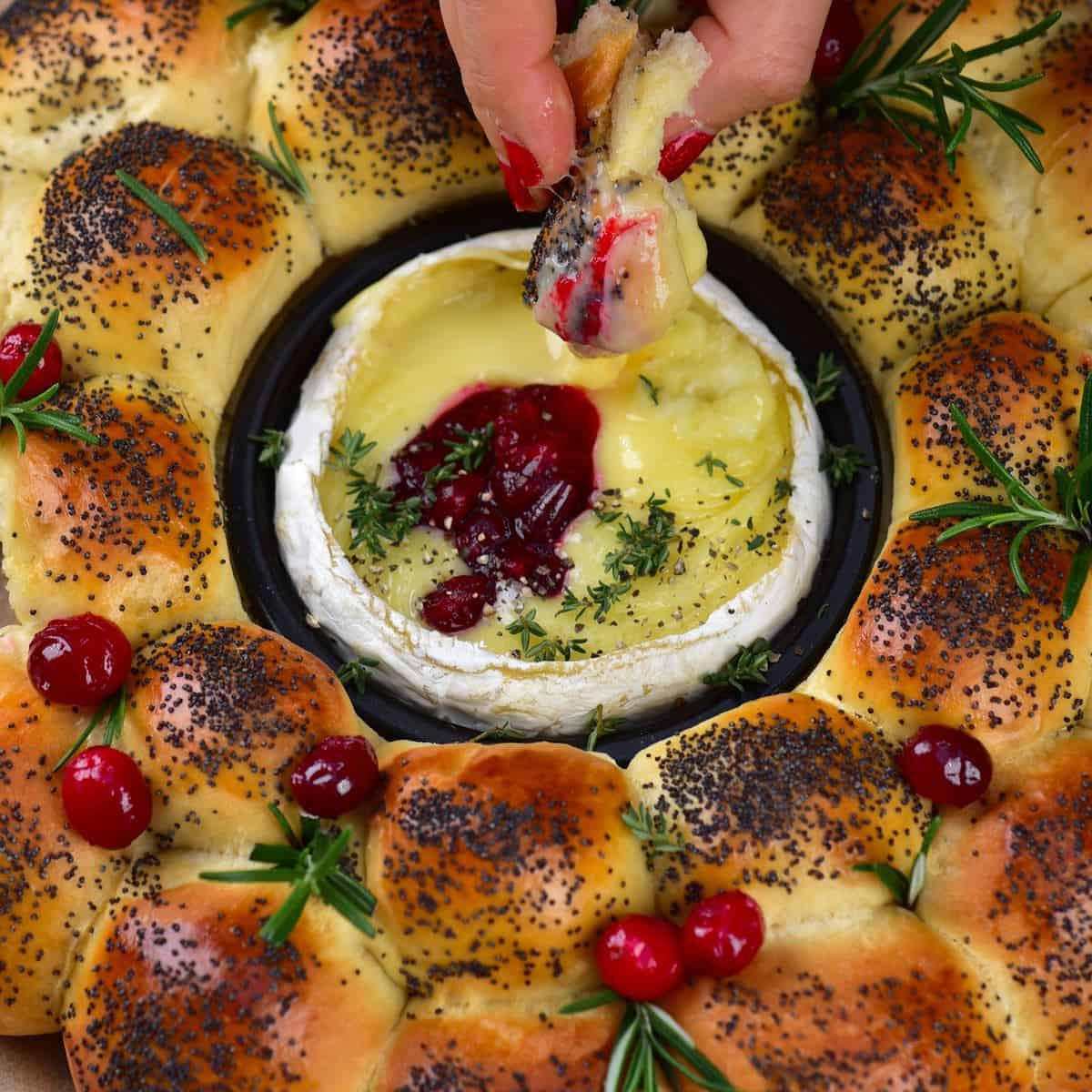 Bun wreath with camembert center topped with cranberries and rosemary