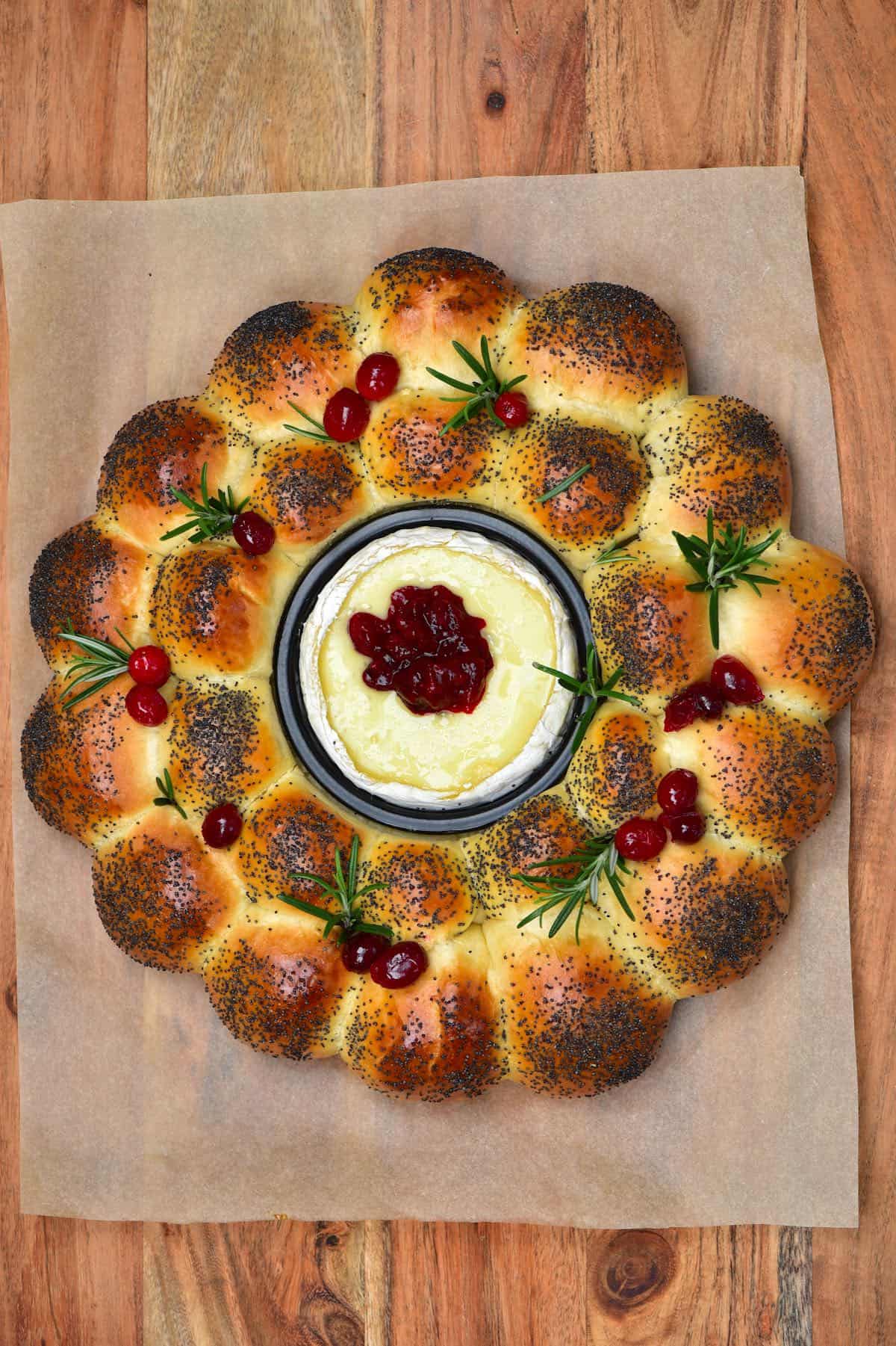 Dinner roll bread wreath with camembert center topped with cranberries and rosemary