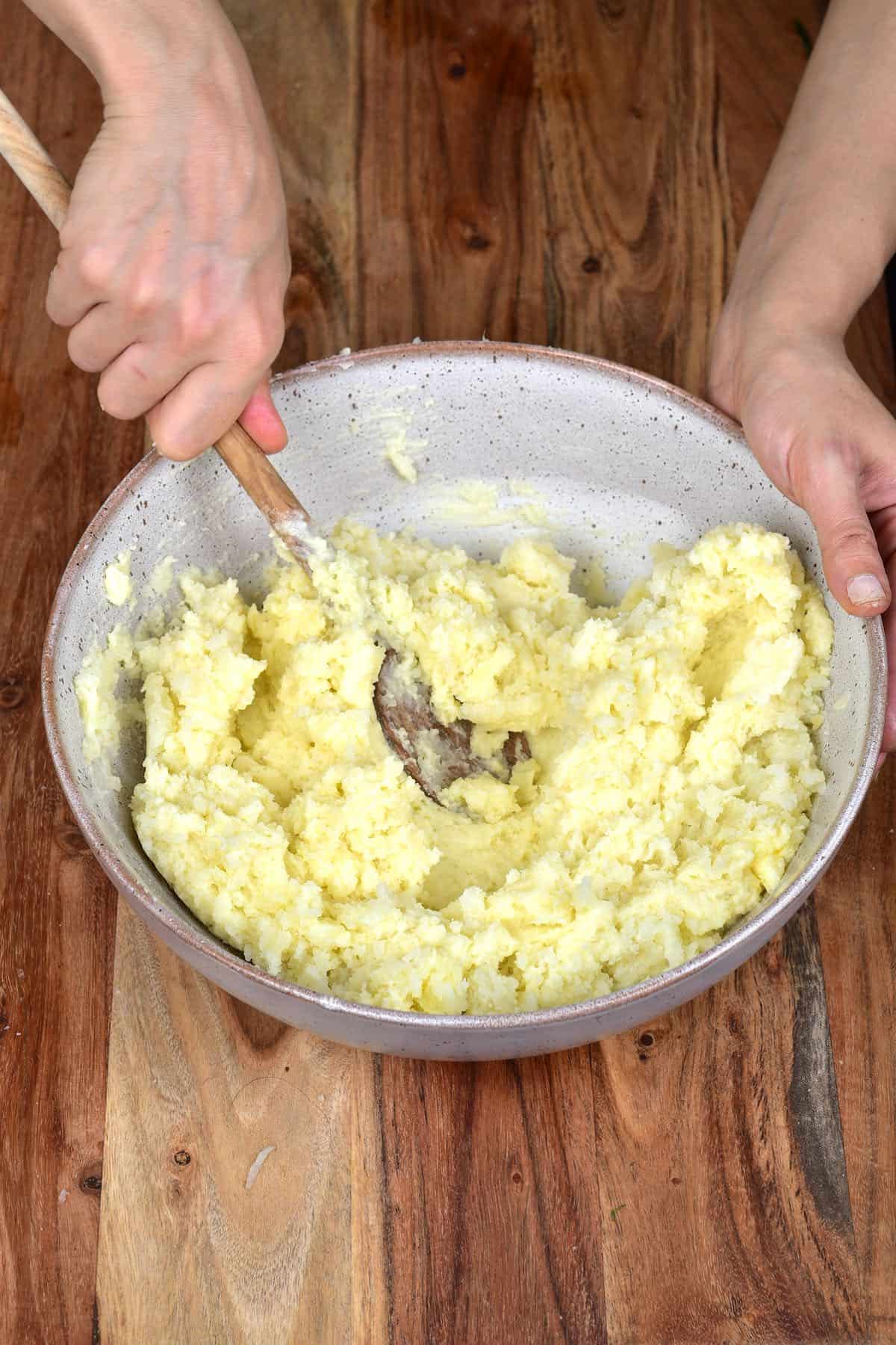 Mixing mashed potatoes with a wooden spoon