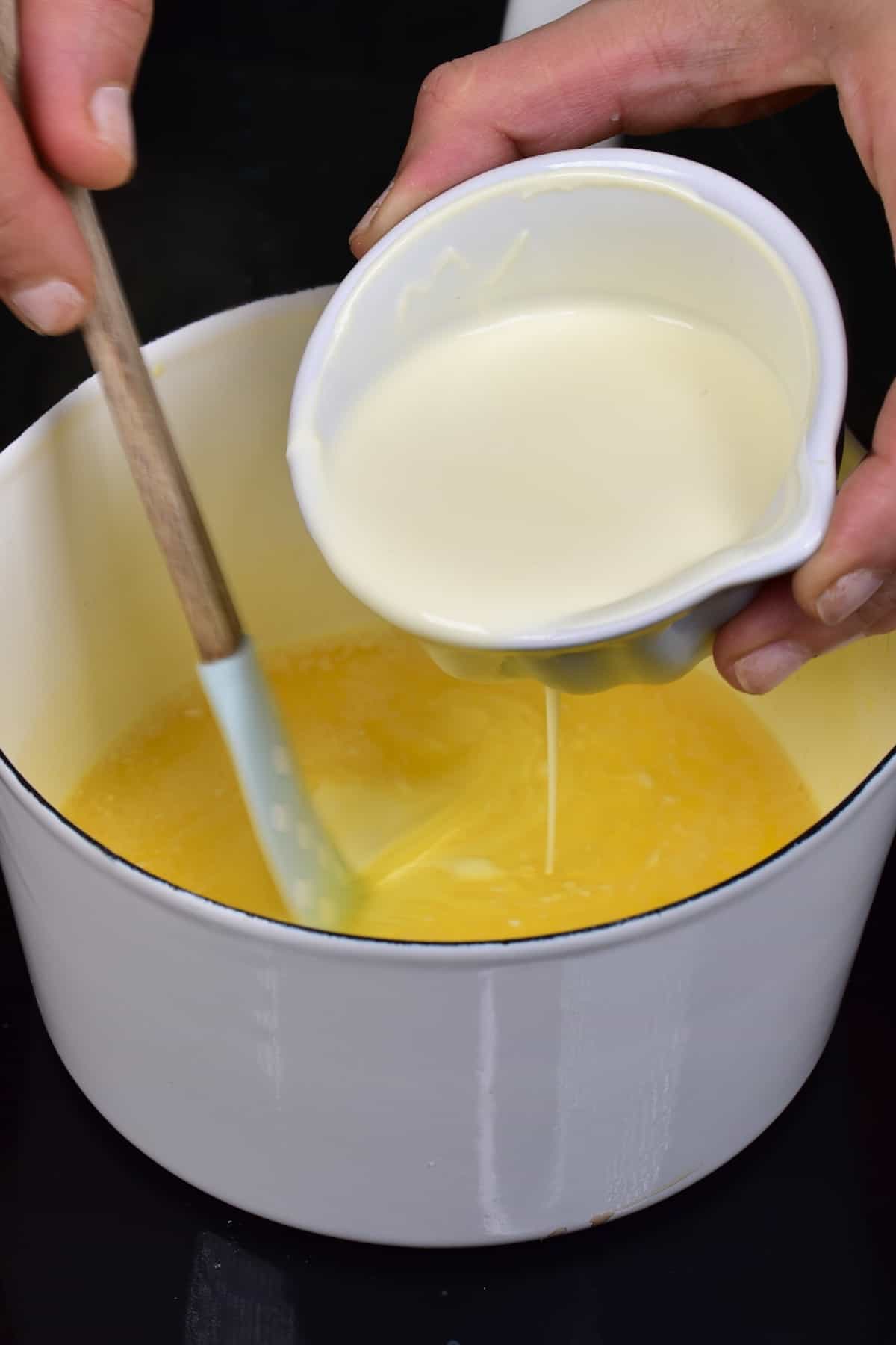Adding cream to melted butter in a pot