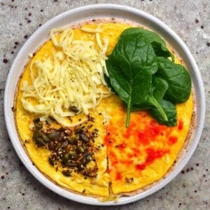 Tortilla topped with omelette cheese spinach and seeds