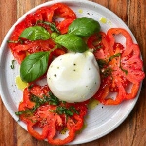 Sliced tomatoes and burrata cheese on a plate