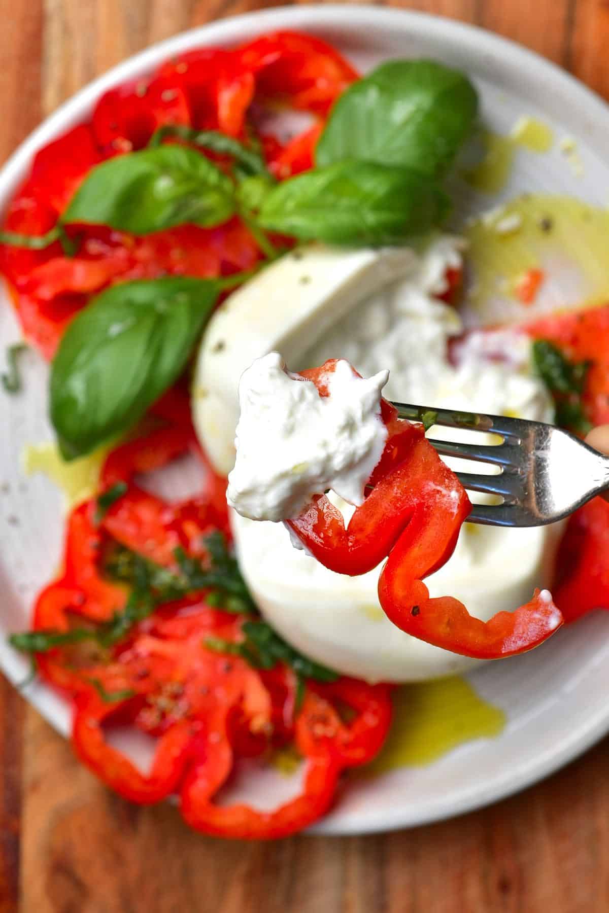 Sliced tomatoes and burrata cheese on a plate