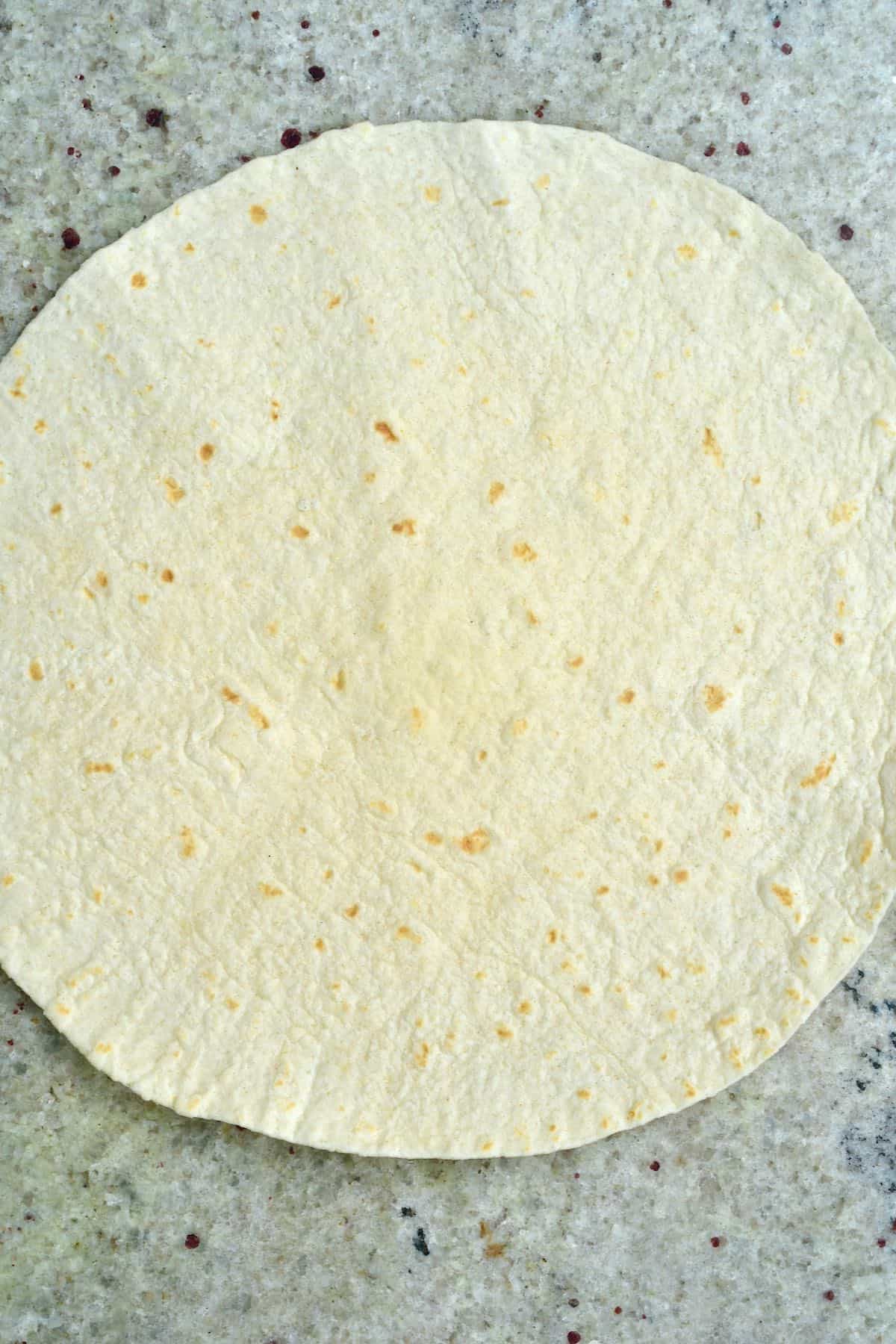 A tortilla on a flat grey surface