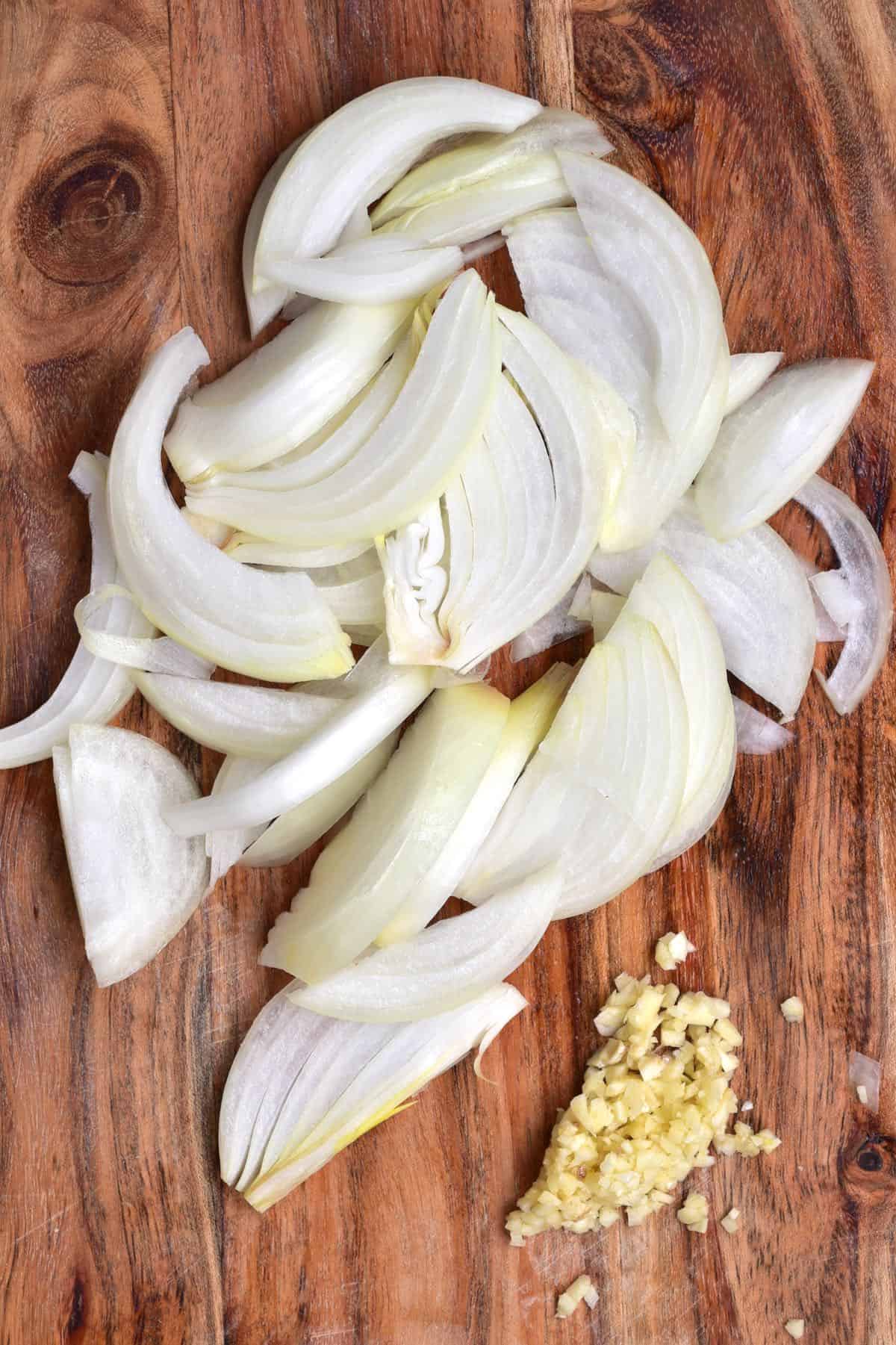 Chopped onion and garlic on a wooden board