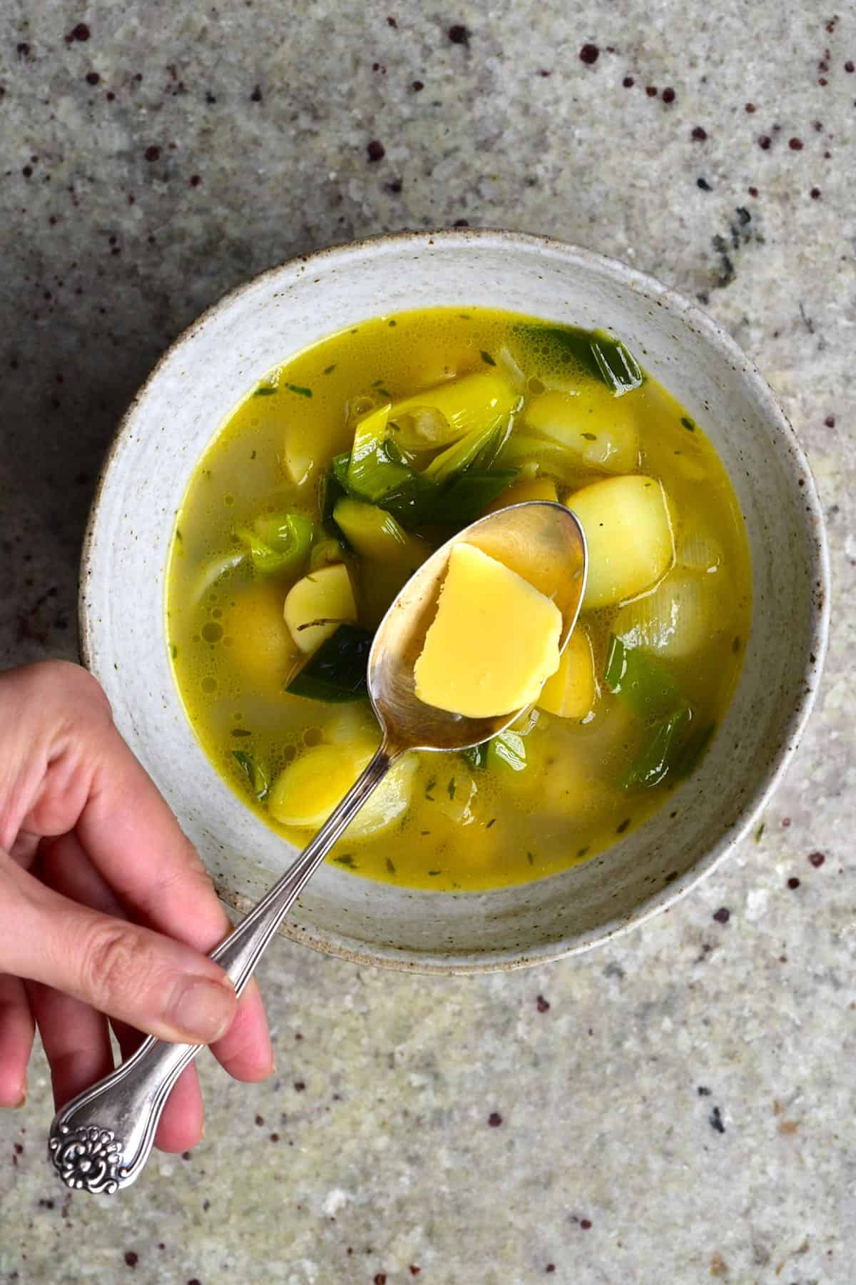 A bowl with potato leek soup and a spoon