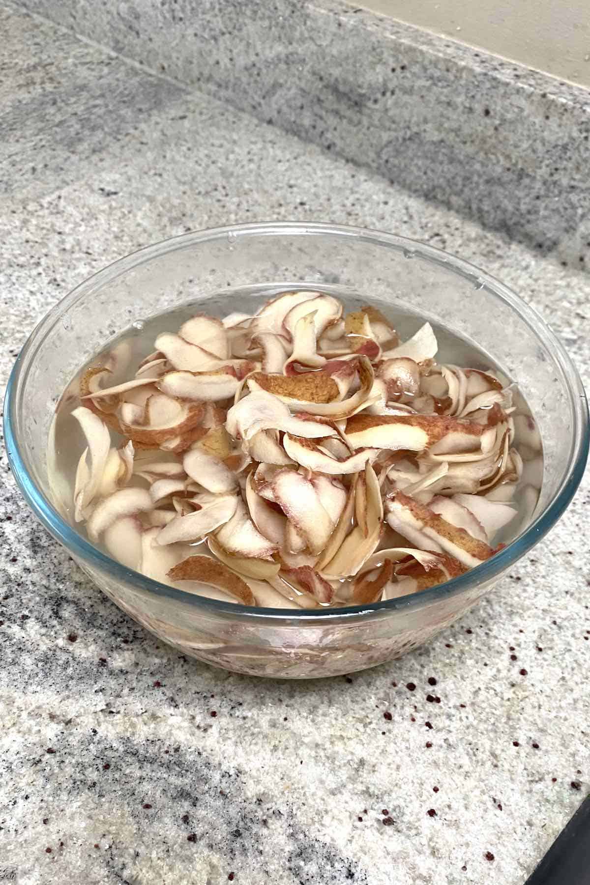 Potato peels soaking in a bowl with water