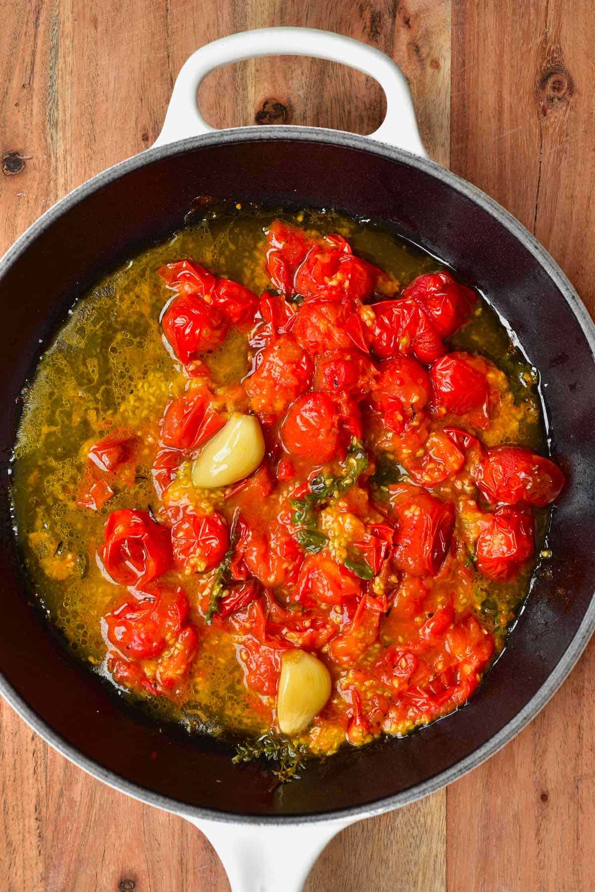 Roasted red tomatoes and garlic in a pan