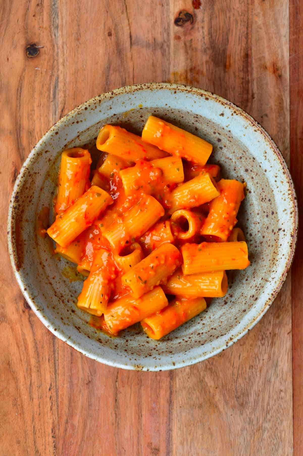 A bowl with penne pasta and tomato sauce