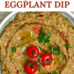 Roasted eggplant dip in a bowl topped with three small tomatoes